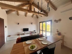 a living room with a wooden table and a dining room at Charming Sardinian Dream Home in Marazzino