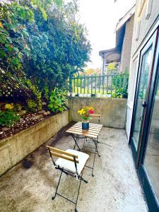 een patio met een tafel, 2 stoelen en een bank bij Bright Garden Suite Across From Park in Kitsilano in Vancouver