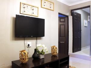 a living room with a television on a wall at The Bethel House in KwaDabeka