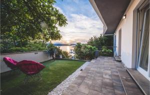 a balcony with a red chair on the grass at Villa Grace in Jadranovo +52 photos