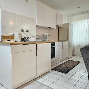 a white kitchen with white cabinets and appliances at My Exclusive Sweet Home S62 in Düsseldorf