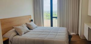 a bedroom with a large bed with a large window at EG12 Playa Grande in Mar del Plata +14 photos