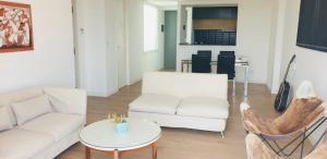 a living room with a white couch and a table at EG12 Playa Grande in Mar del Plata