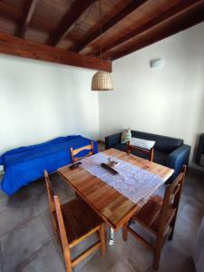 a dining room with a table and a blue couch at Javier 1 in Santa Teresita