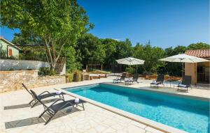 a swimming pool with chairs and umbrellas in a yard at Villa Stora Kuca in Krapan