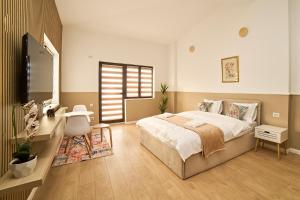 a bedroom with a bed and a desk and a mirror at Dona Premier Suites in Bucharest