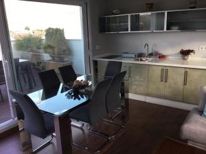 a kitchen with a glass table and chairs in a room at Casa Caballero de la Rosa in Priego de Córdoba
