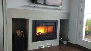 a fireplace in a living room with a fire in it at Casa Caballero de la Rosa in Priego de Córdoba