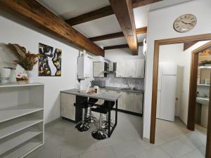 a kitchen with a table and a clock on the wall at Monnalisa House - Imola Centro Storico - Appartamento Indipendente in Imola +31 photos