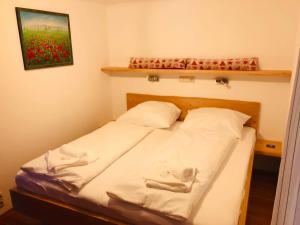 a bedroom with a bed with white sheets and red flowers at Ski in & Ski out Apartment at Chalet Heinrich in Sonnenalpe Nassfeld