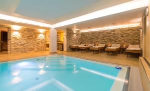 a swimming pool in a hotel with tables and chairs at Hotel Süd Graz in Graz