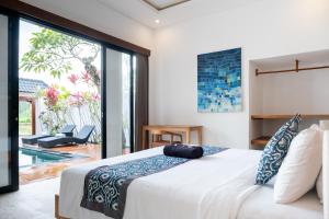 Un dormitorio con una cama y una puerta corrediza de vidrio. en Entire villa Luxury Peaceful Pool Views Ubud, en Ubud 26 fotos más