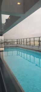 a large swimming pool with blue water at MOEMA54 - Studio novo e completo na melhor localização de Moema, ao lado do Shopping Ibirapuera in Sao Paulo