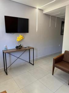 Una sala de estar con una mesa con un televisor en la pared. en Flat indians Parque das nacoes indigenas, en Cuiabá
