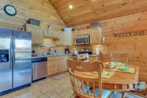 Una cocina con una mesa y un refrigerador de acero inoxidable. en 1 Mi to Current River Sunset-View Van Buren Cabin, en Van Buren