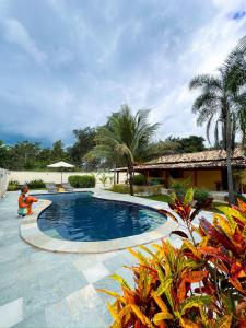 a swimming pool in a yard with trees and a building at chacara sombra da mata01 in Pirenópolis