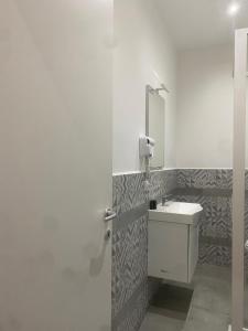 un bagno con lavandino e specchio di Appartamenti 5min da stazione centrale a Milano