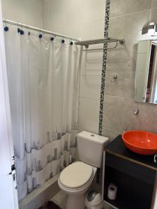 a bathroom with a toilet and a sink at Kaizen Apart Departamento 3 in Caleta Olivia +27 photos