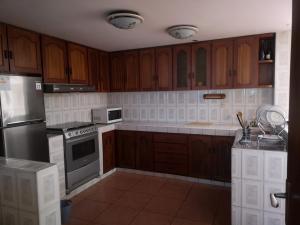 a kitchen with wooden cabinets and stainless steel appliances at La Casa Junto Al Rio in Arequipa