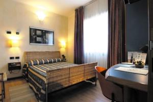 1 dormitorio con 1 cama y escritorio en una habitación en Hotel Alexander, en Fiorano Modenese