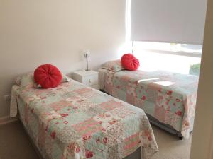 2 camas en una habitación con almohadas rojas. en Renaca apartment, en Viña del Mar