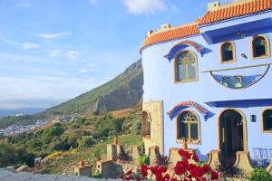 a house on the side of a hill with flowers at Haven Hills Social Club in Chefchaouene