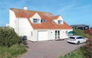 a white house with a car parked in a driveway at Holiday Home Nørre Nebel 56 in Nymindegab