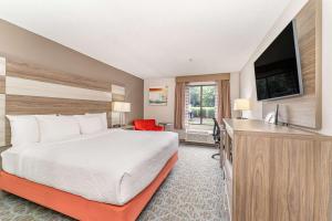 a hotel room with a bed and a flat screen tv at Best Western Kernersville in Kernersville