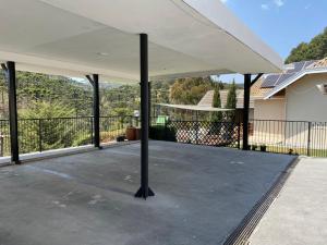 um pátio vazio com uma cobertura branca numa casa em Casa dos Neves Suíte Master em Campos de Jordão