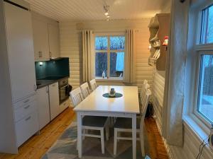 a small kitchen with a white table and chairs at Arctic Aurora View in Ytre Tomasjord