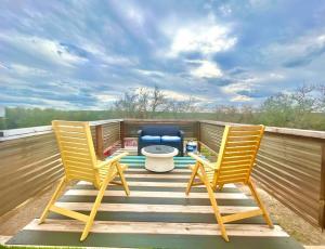 - deux chaises et des toilettes sur une terrasse dans l'établissement 40'Container withOutdoorBedroom 35miles NW of DwnTwn ATX, à Leander