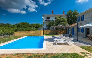 a swimming pool with chairs and a house at Villa Laura Ripenda in Ripenda Kras