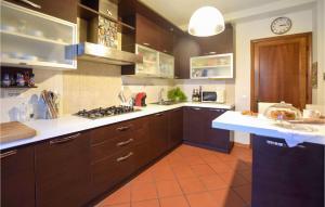 a kitchen with brown cabinets and a clock on the wall at 1 Bedroom Cozy Apartment In Massarosa in Massarosa