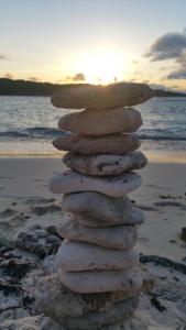 a stack of rocks on the beach at sunset at L'écrin Vert in Sainte-Anne +25 photos