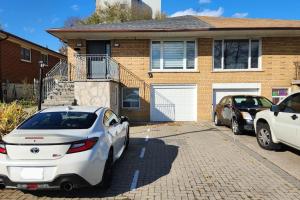 a white car parked in front of a house at 2 bedroom rental apartment , 1 sofa bed, 2 car parking in Mississauga