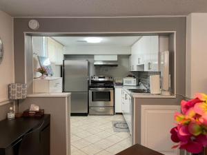 a kitchen with white cabinets and stainless steel appliances at 2 bedroom rental apartment , 1 sofa bed, 2 car parking in Mississauga
