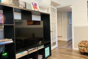 a large black entertainment center with a flat screen tv at 2 bedroom rental apartment , 1 sofa bed, 2 car parking in Mississauga