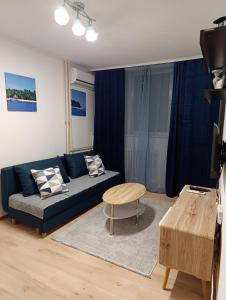 a living room with a blue couch and a table at Aurum29 in Doboj