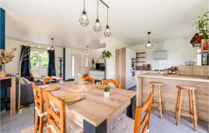 kuchnia i jadalnia z drewnianym stołem i krzesłami w obiekcie Cozy Home In Lyons-La-Forêt w mieście Lyons-la-Forêt