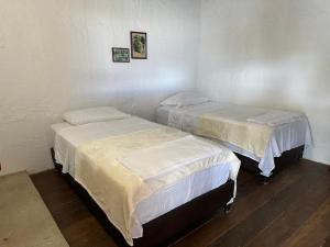 twee bedden in een kleine kamer met ermottermott bij Apartamento Ines María in Barichara