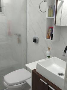 a bathroom with a toilet and a sink and a shower at Apartamento proximo a praia in Matinhos