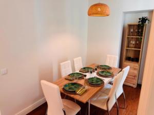 a dining room table with white chairs and a wooden table with green plates at Augusta Luxury Apartment - near praça do comércio in Lisbon +9 photos