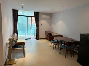 ein Zimmer mit einem Schreibtisch und einem Tisch und Stühlen in der Unterkunft Trinh CSJ Tower 169 Thuỳ Vân in Vũng Tàu