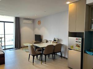 a kitchen and dining room with a table and a refrigerator at Trinh CSJ Tower 169 Thuỳ Vân in Vung Tau