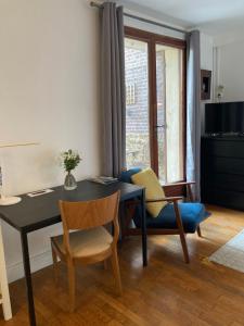 a living room with a table and chairs and a window at Studio avec terrasse sur jardin in Fontenay-sous-Bois