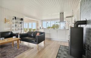 a living room with black leather furniture and a kitchen at Three-Bedroom Holiday Home In Fur in Fur