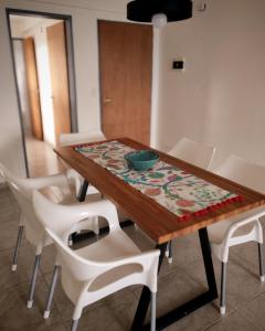 Una mesa de madera con sillas blancas y un cuenco encima. en De cara al lago Bariloche U4, en San Carlos de Bariloche