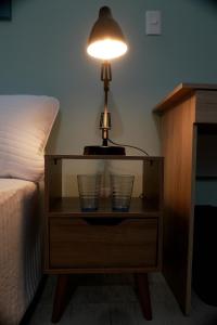 a lamp on a night stand next to a bed at Ideal para trabajar y descansar in Cali