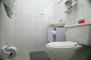 a white bathroom with a toilet and a sink at Ideal para trabajar y descansar in Cali