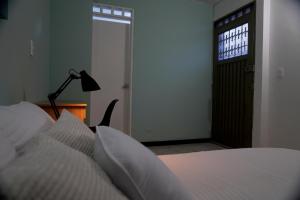 a bedroom with a bed and a lamp and a door at Ideal para trabajar y descansar in Cali